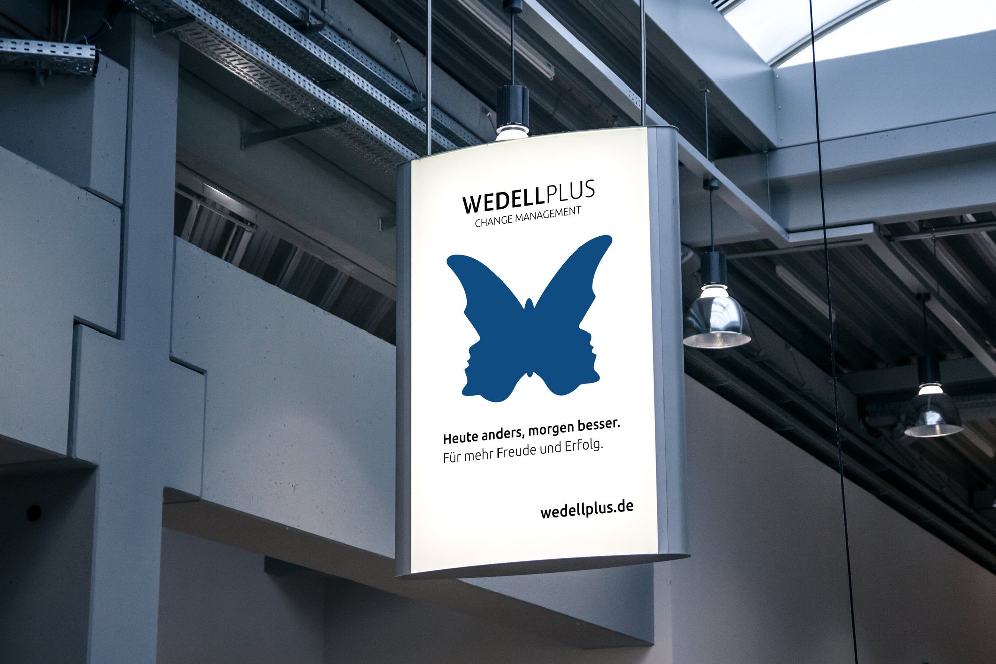 Leichtendes Werbeplakat von Wedell Plus an einer hohen Decke hängend